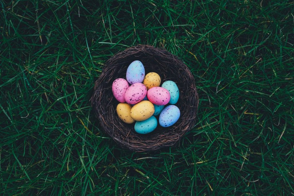 Coloured eggs in a basket on grass